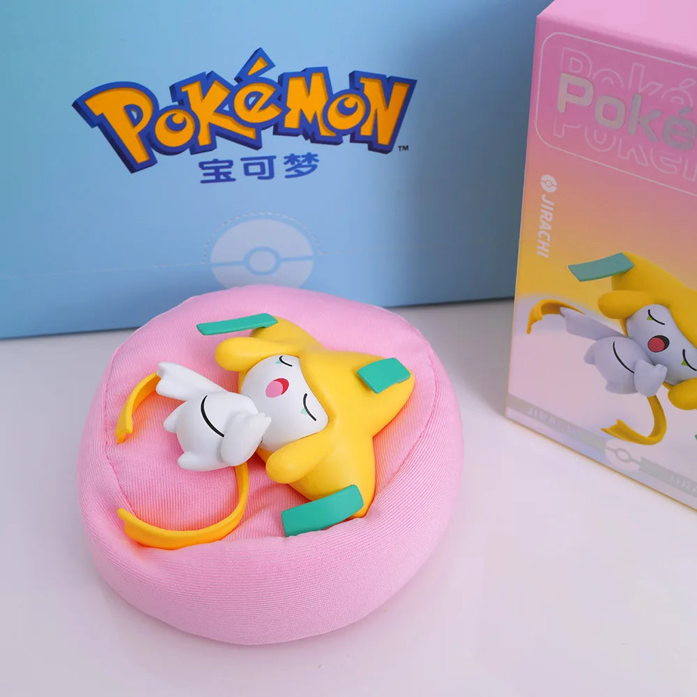 irachi figurine sleeping on a pink cushion/pillow, showcasing its cute design, with a Pokémon-themed box and branded background.
